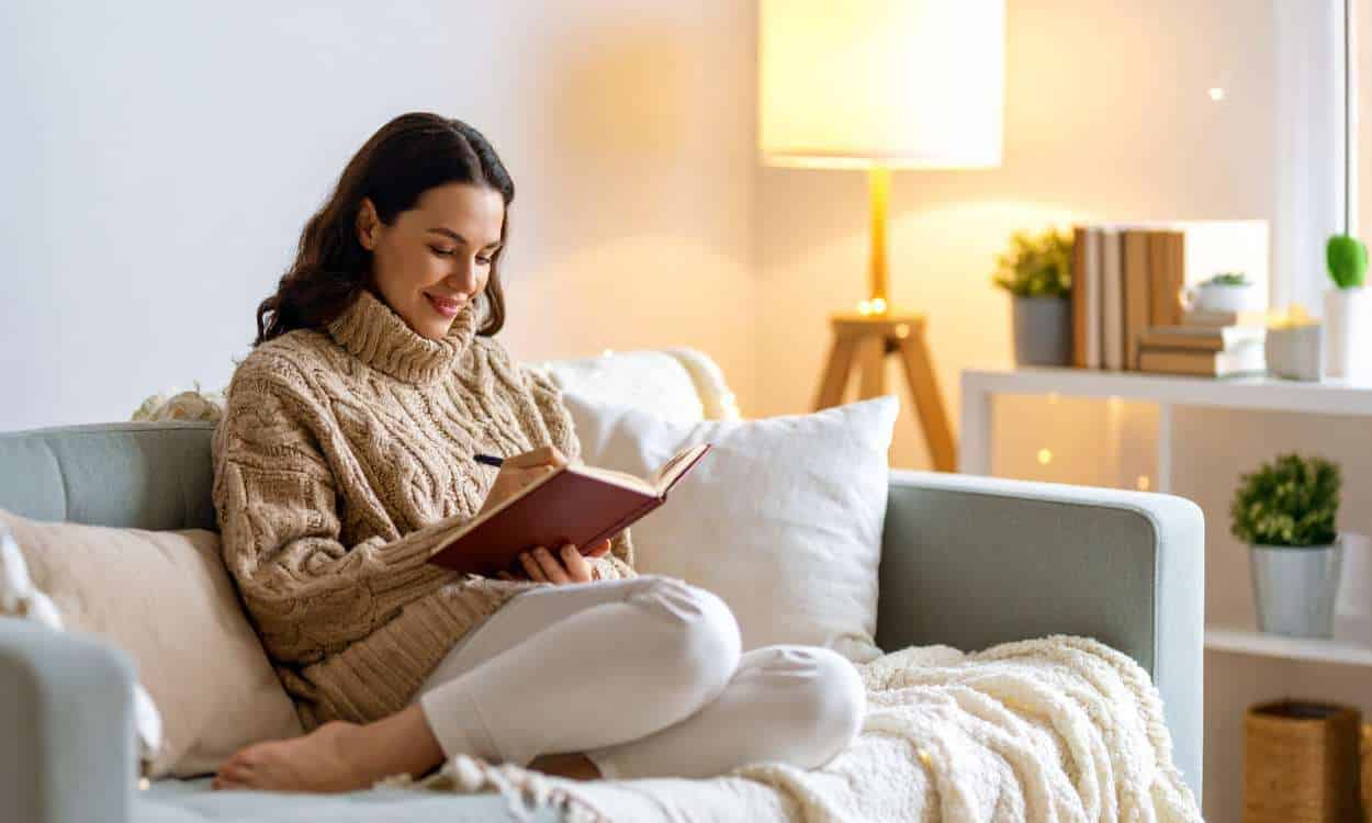 Woman journaling alone in a quiet room, symbolizing emotional healing and self-connection through grief journaling.